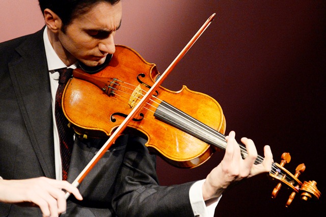 US violist David Aaron Carpenter plays the "Macdonald" Stradivarius viola created in 1719 by Antonio Stradivari (1641-1737), at Sotheby's auction house in Paris on April 15, 2014. Sotheby's announced the sale of the viola for this spring 2014 in New York, estimated to sell in excess of 45 million US dollars.  AFP PHOTO BERTRAND GUAY
